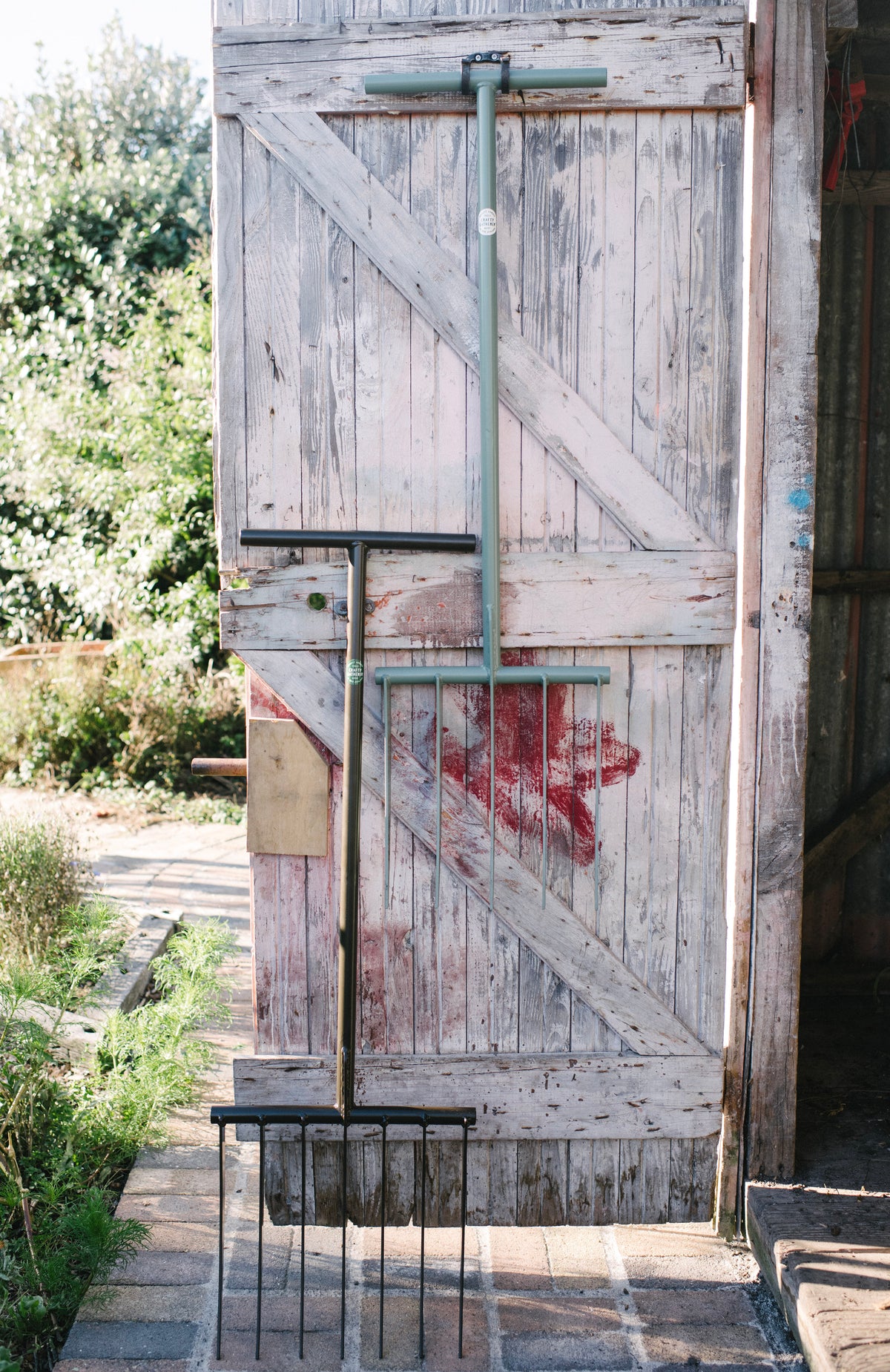 7-tine and 5-tine  garden forks hanging in garden shed