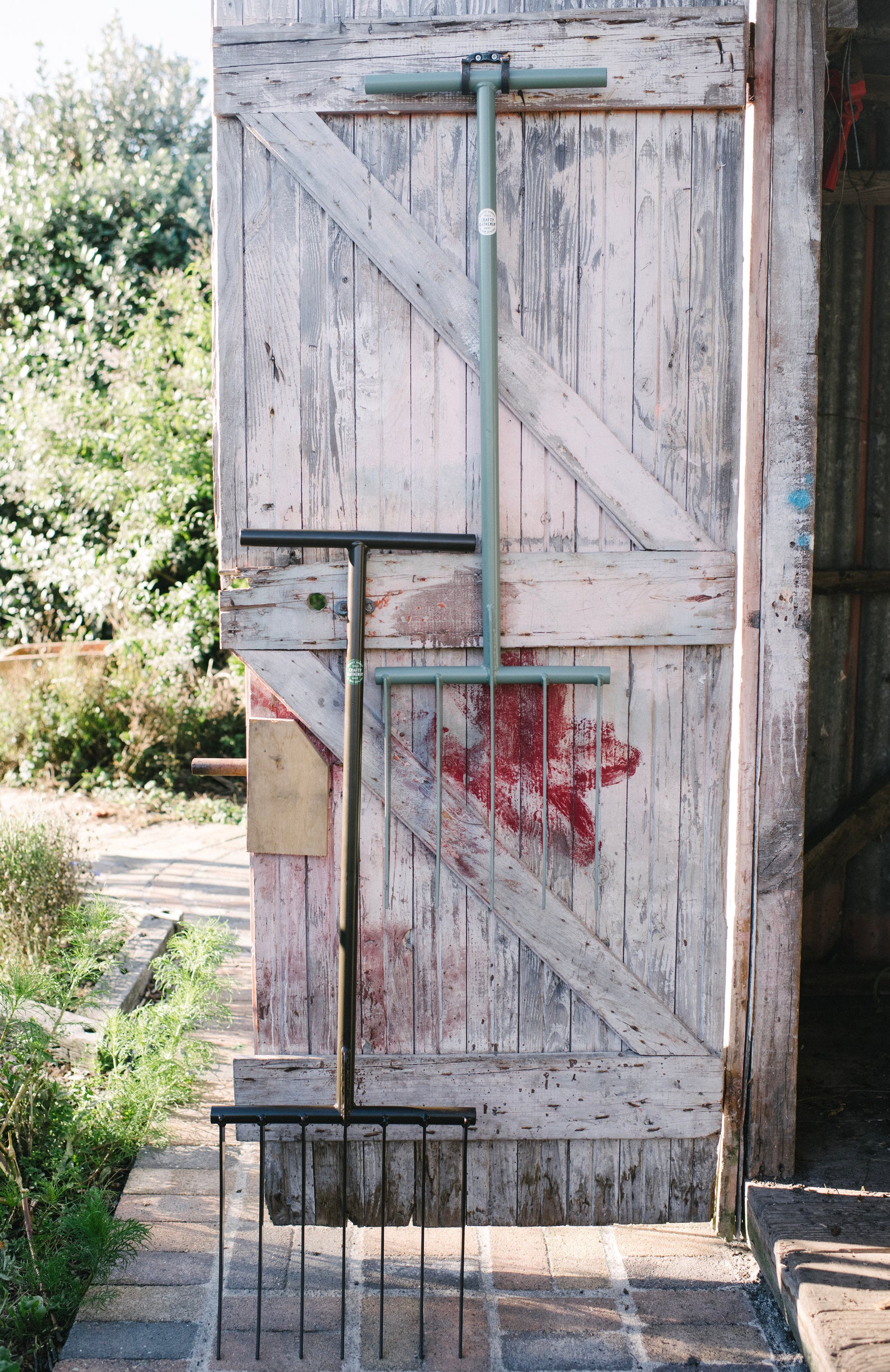 7-tine and 5-tine  garden forks hanging in garden shed